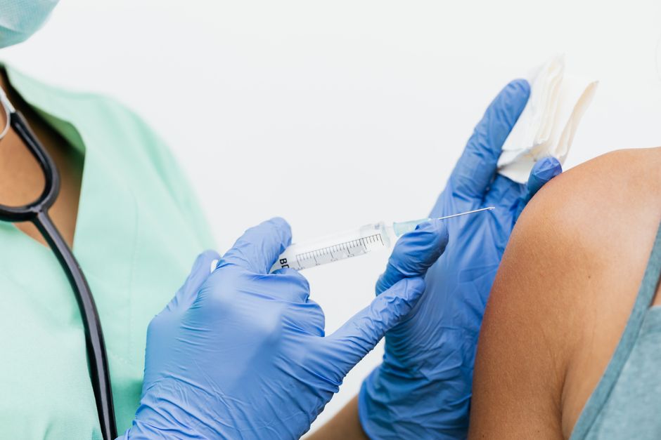 Nurse in gloves administering a flu vaccination to a patient