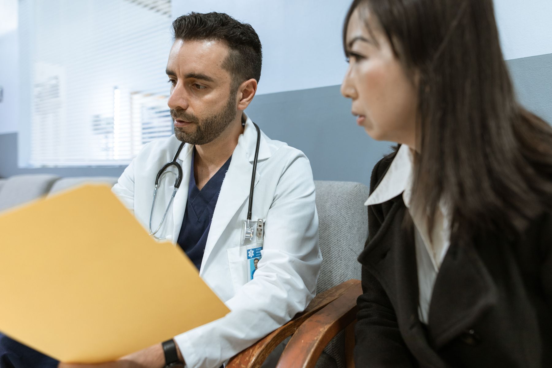 Doctor reviewing health records with a patient during a consultation, representing choosing a primary care doctor