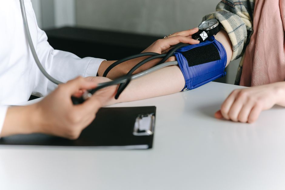 Healthcare provider checking a patient blood pressure during a primary care visit